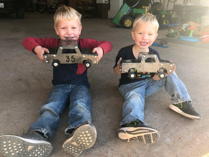 Two young boys smiling with their Metal Toy Construction Truck - Build and Play - designed by HL Guest Handmade